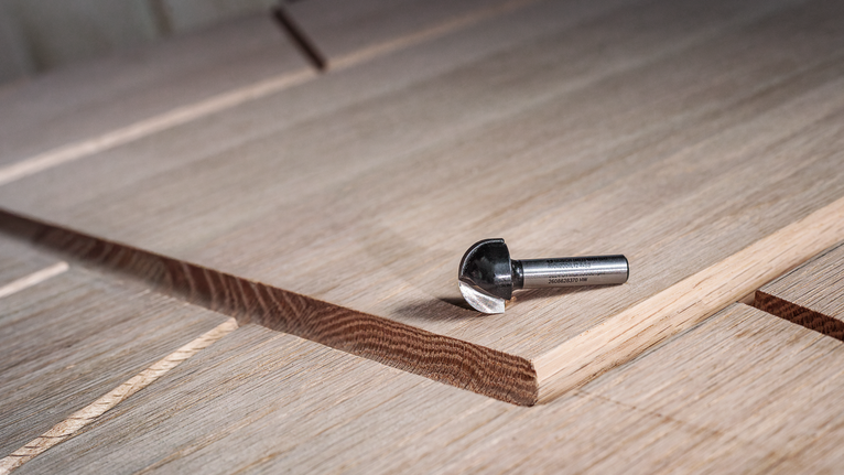 硬質合金銑刀放在帶有新切槽的層壓木板上。.