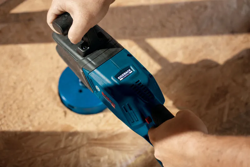 一個人在木質表面上操作藍色無線角鑽。.