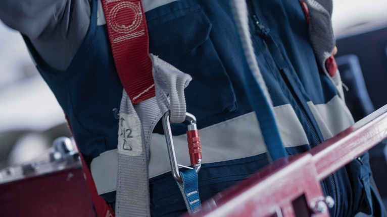 配戴安全設備並由安全帶和登山扣固定的人員。.