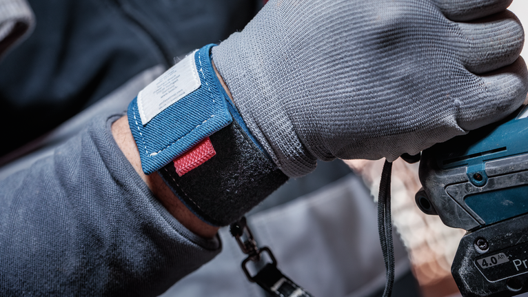 配戴安全設備的人員操作電動工具。.