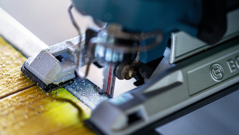 拼圖鋸切割木板，產生細小的鋸末。.