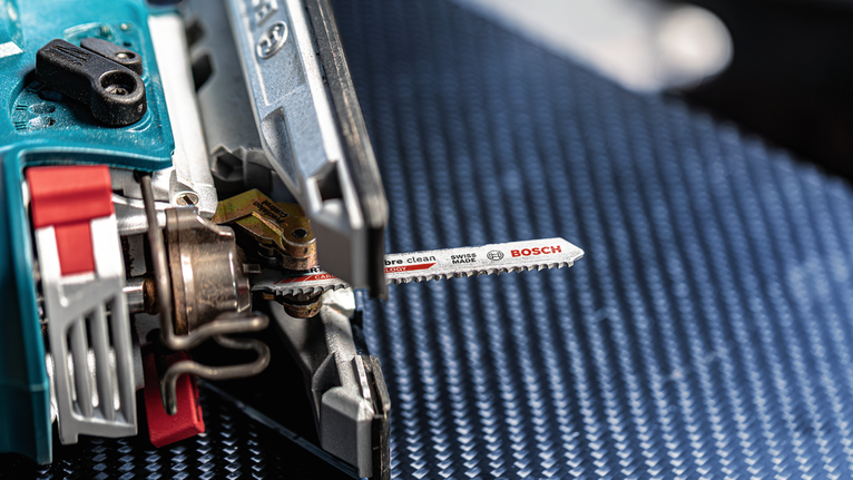 帶有金屬刀片的拼圖，放置在帶有紋理的藍色表面上。.