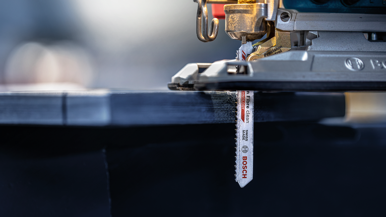 拼圖鋸切割一塊層壓木板。.