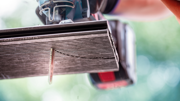 一名配戴安全設備的人員使用電鋸切割磁磚。.