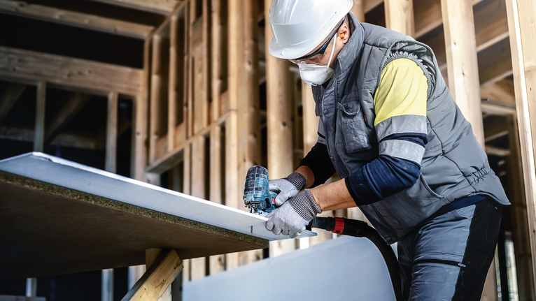 EXPERT ‘Fiber Plaster’ T 141 HM 線鋸片 3 件式 配戴安全設備的人員使用電鑽對建築框架內的石膏板進行鑽孔。.