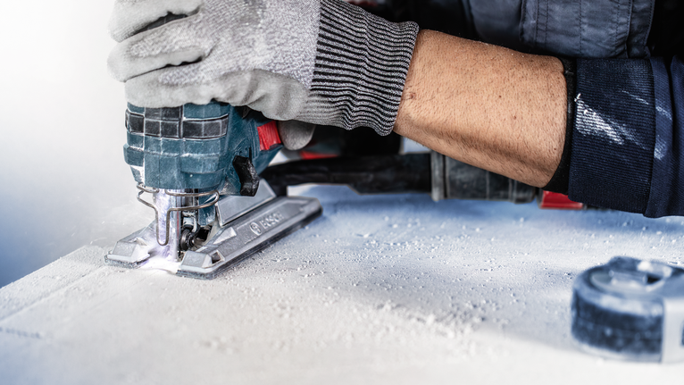 EXPERT ‘Fiber Plaster’ T 141 HM 線鋸片 3 件式 配戴安全設備的人員使用曲線鋸切割一片材料。.