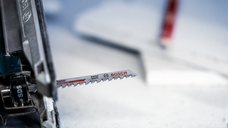 EXPERT ‘Fiber Plaster’ T 141 HM 線鋸片 3 件式 安裝在電動工具上的拼圖鋸刀片,準備進行切割。.