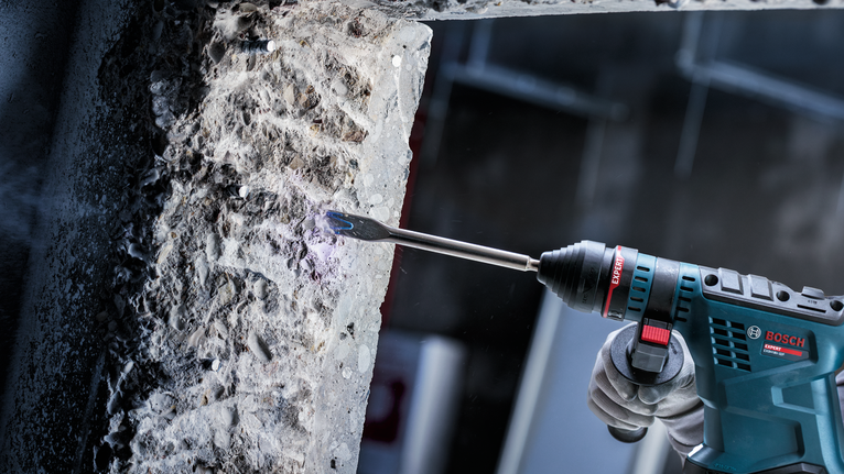 配戴安全設備的人員使用旋轉錘鑿開混凝土。