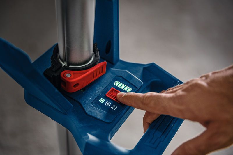 一名工作人員正在使用數位控制面板調節無線工地照明燈。