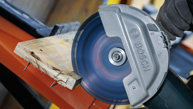 一名佩戴安全設備的人員使用圓鋸切割木板。