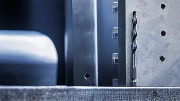 金屬鑽頭垂直放置在加工過的金屬表面上。