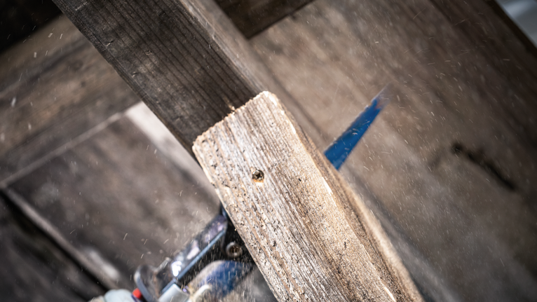 電動工具切割木板，木屑飛濺。