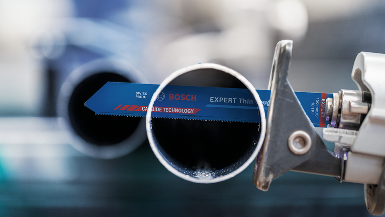 在工業環境中，往復鋸片正在切割金屬管。