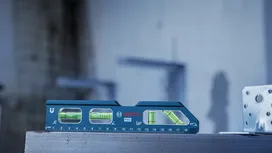在建築工地上，藍色水平儀放在金屬表面上。