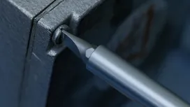 用螺絲起子鎖緊金屬電工盒上的螺絲。