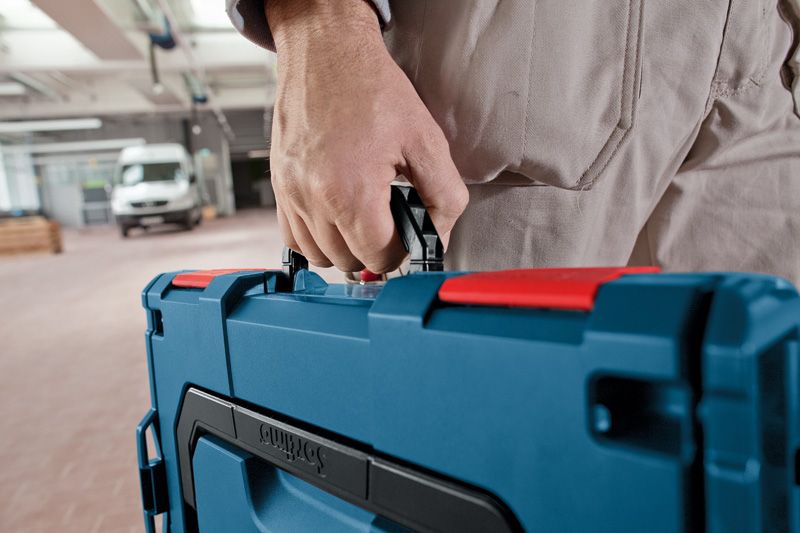 車間內一名人員攜帶藍色工具箱。.