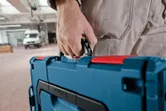 車間內一名人員攜帶藍色工具箱。