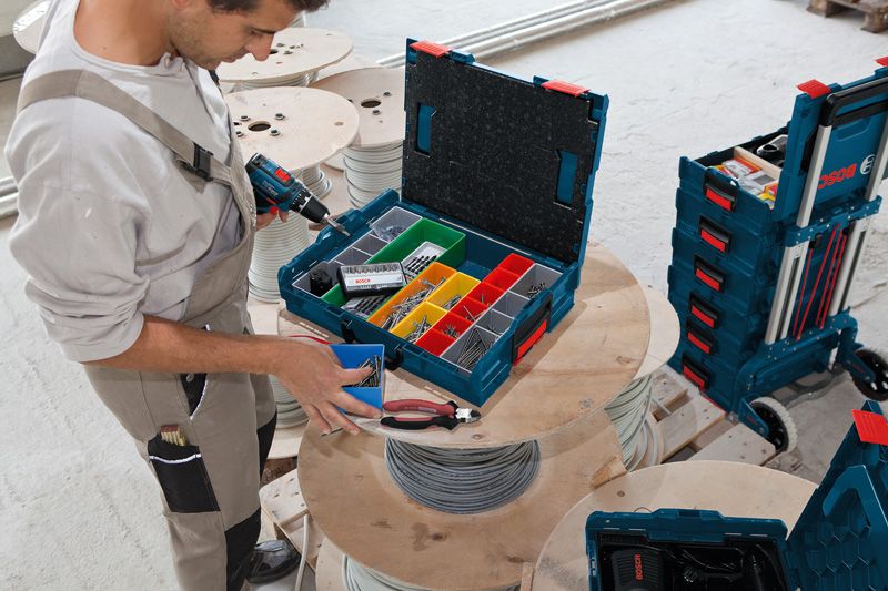 一名工作人員在車間整理工具箱中電纜捲軸上的緊固件。.