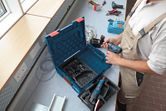 一名配戴安全設備的人員在工作站準備無線電鑽。